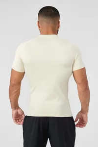 Rear view of a men's cream-colored athletic compression shirt showing muscle definition.