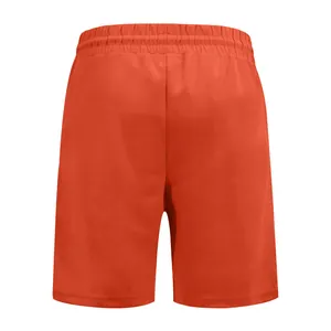 Vista dettagliata del retro dei pantaloncini da golf arancioni da uomo con coste fini.