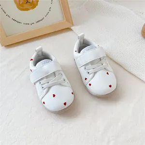 Witte babyloopschoentjes met zachte zool, rode geborduurde hartjes en klittenband