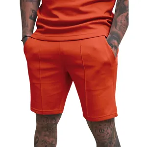 Close-up of vibrant orange men's athletic shorts showing front seam details and pockets