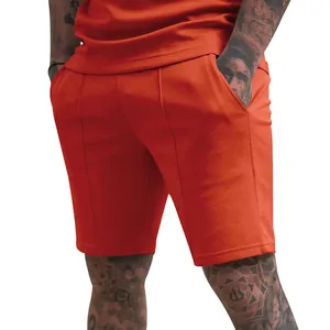 Close-up of men's orange fitness sports shorts with vertical seam detail