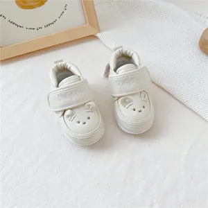 Vue détaillée de chaussures pour bébé couleur crème avec tête d'ours mignonne