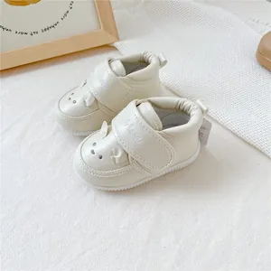 Détail de chaussures de marche pour bébé de couleur crème avec motif animal brodé