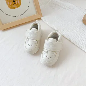 Vue détaillée de chaussures de marche pour bébé crème avec motif de tête d'ours