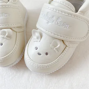 Gros plan d'une broderie d'animal sur des chaussures de marche pour bébé en cuir
