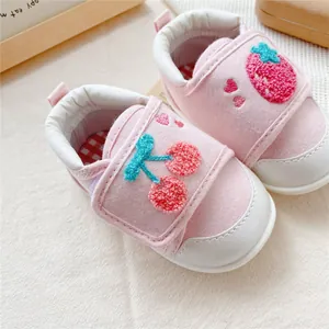 Close-up of pink soft-soled baby walking shoes with cute strawberry and cherry embroidery