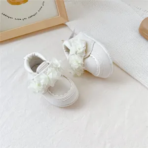 Vue détaillée de chaussures de marche blanches pour bébé avec fleurs et semelles souples
