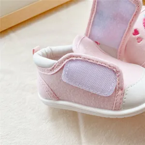 Close-up detail of the adjustable Velcro strap on a pink baby soft sole walking shoe