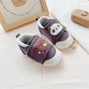 Detailed view of the cute bear and panda character patches on baby soft sole walking shoes