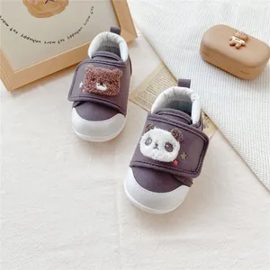 Detail of mismatched baby toddler shoes featuring fuzzy bear and panda cartoon patches