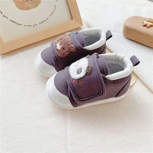Close-up of purple baby walker shoes with cute panda and bear patches for toddlers.