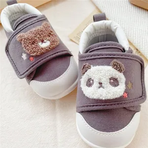 Detail view of baby soft sole walking shoes featuring cute bear and panda embroidery.