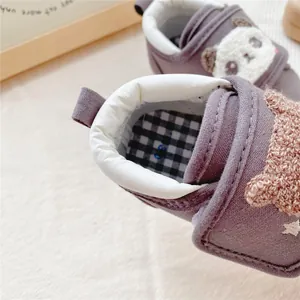 Detail of soft infant walking shoe featuring checkered insole and cute panda design