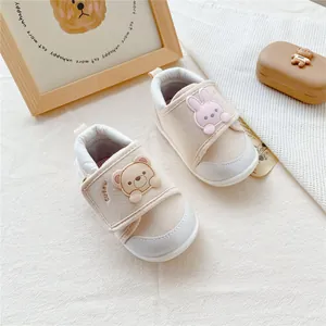 Detail of cute cartoon bear and rabbit baby walking shoes with soft soles.