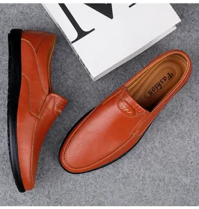Draufsicht-Detail von braunen Leder-Business-Loafers mit Ziernähten auf grauem Filz.