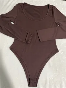 Close-up of a brown ribbed long-sleeve bodysuit with a round neck and snap closure