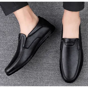 Detailansicht von schwarzen Herren-Slippern aus Leder auf strukturiertem Boden.