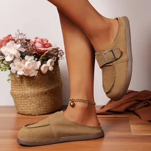 Gros plan détaillé de mules plates vintage en daim kaki avec une boucle en métal élégante