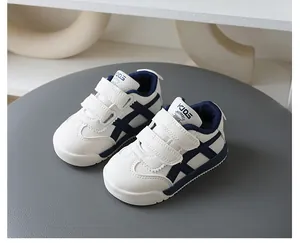 Seitenansicht der weiß-blauen Kinder-Turnschuhe im German Trainer-Stil mit Klett