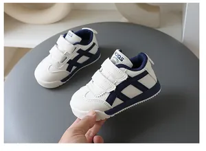Weiße und marineblaue Kindersneaker mit weicher Sohle und Klettverschluss-Design