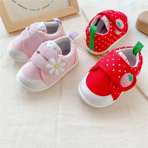 Detail van schattige baby-loopschoenen met zachte zool en madeliefje- en aardbeipatronen