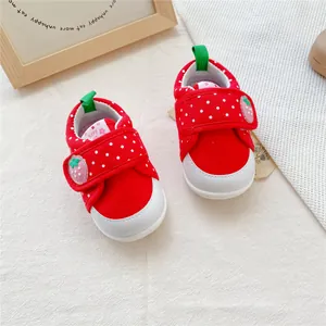 Bovenaanzicht van rode aardbei babyloopschoenen met witte stippen en klittenbandsluiting