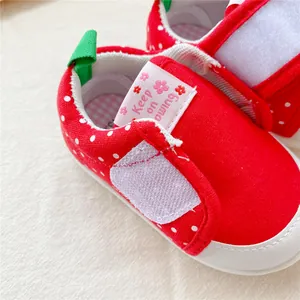 Gedetailleerde opname van rode aardbei stip baby loopschoentjes met klittenbandsluiting