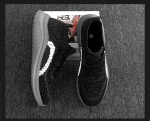 Vue de dessus de baskets en maille noire pour hommes avec rayures réfléchissantes et semelles grises