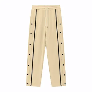 Pantaloni beige da uomo con strisce laterali nere e bottoni a pressione in metallo