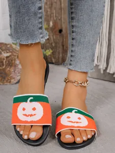Detalle de chanclas planas para mujer con patrón de calabaza tejido para Halloween