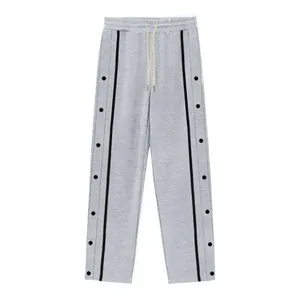 Vista frontale pantaloni grigi con bottoni a pressione laterali e strisce nere