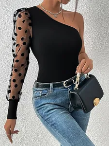 Haut noir chic à une épaule avec manche en mesh à pois pour un look très élégant