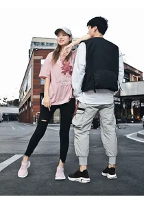 Couple wearing breathable fly-knit sneakers in a casual outdoor urban street setting
