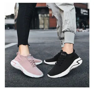 Outdoor detail shot of breathable fly-knit sneakers in pink and black for couples.