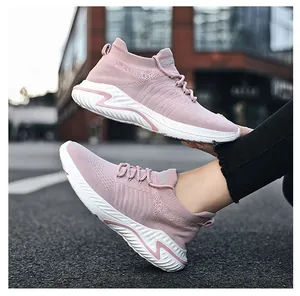Close-up of pink breathable knitted slip-on sneakers for women on street background