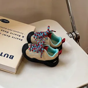 Λεπτομερής προβολή παιδικών φθινοπωρινών sneaker από μπεζ σουέτ με πλεγμένα κορδόνια.