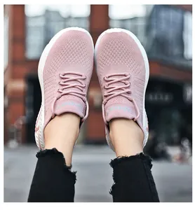 Close-up view of pink fly-knit breathable sports shoes with textured knit patterns
