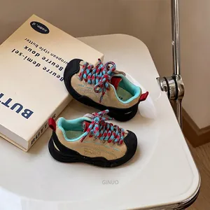 Detail view of khaki kids sneakers with blue laces and reinforced rubber toe cap