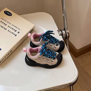 Close-up of khaki baby walking shoes with blue patterned laces on a white table