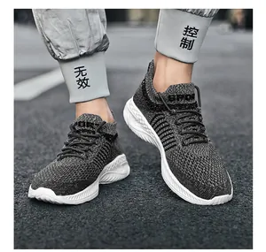 Close-up of breathable grey flyknit sneakers with durable white wavy soles for sports.
