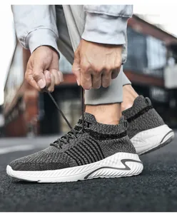Close-up of breathable grey flyknit sneakers with textured white soles and black laces