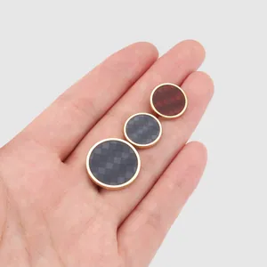 Elegant circular metal and resin patchwork buttons with checkered pattern shown in hand