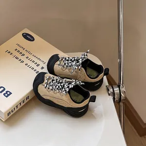 Detailed view of khaki toddler sneakers with protective black toe cap and patterned laces
