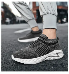 Close-up detail of grey breathable knit slip-on sneakers with durable white rubber sole