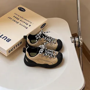 Close-up of children's tan toddler sports shoes with checkered laces and black soles