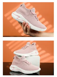 Detailed view of pink flyknit sports shoes on a white pedestal and held by hand