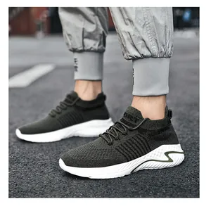 Detail shot of lightweight olive green fly-knit sport sneakers on urban asphalt