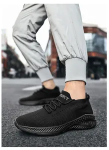 Detailed view of black breathable flyknit sneakers worn by a person on a city street