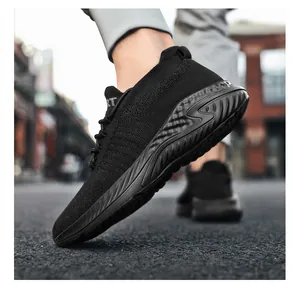 Close-up detail of black breathable fly-knit slip-on sports shoe with textured sole