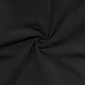 Close-up detail of black breathable linen fabric texture with a natural wrinkled finish effect
